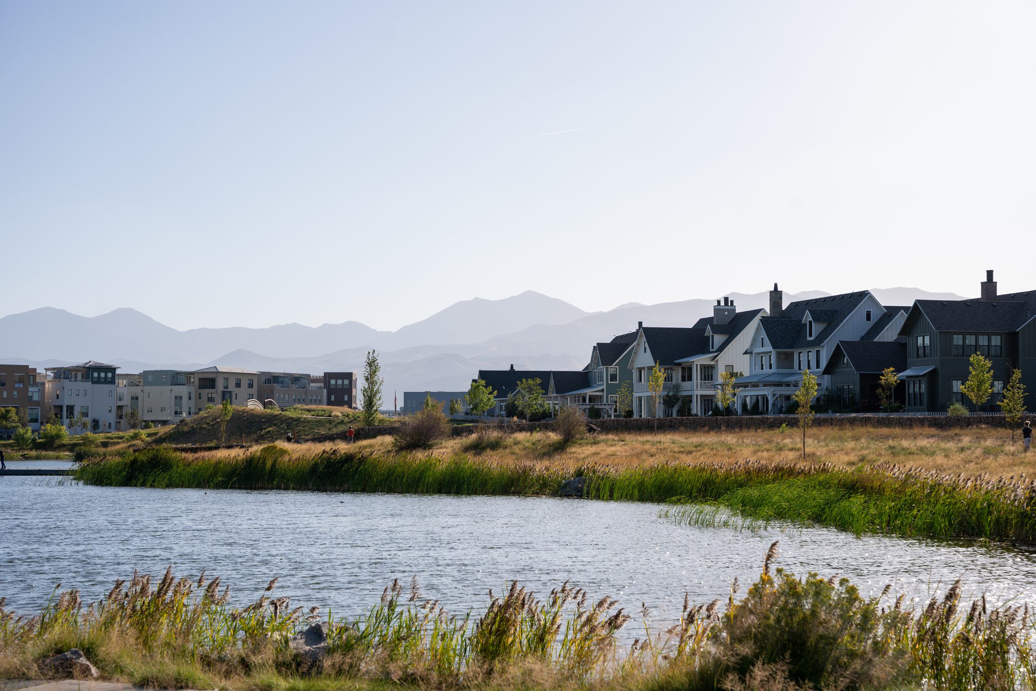 A Clear Sky Early Evening Shot of Homes and Condos Next to Oquirrh Lake in Daybreak Utah