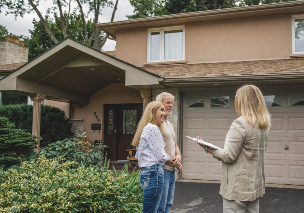 Homebuyers discussing property with agent